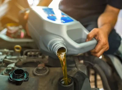 Car,Mechanic,Replacing,And,Pouring,Fresh,Oil,Into,Engine,At